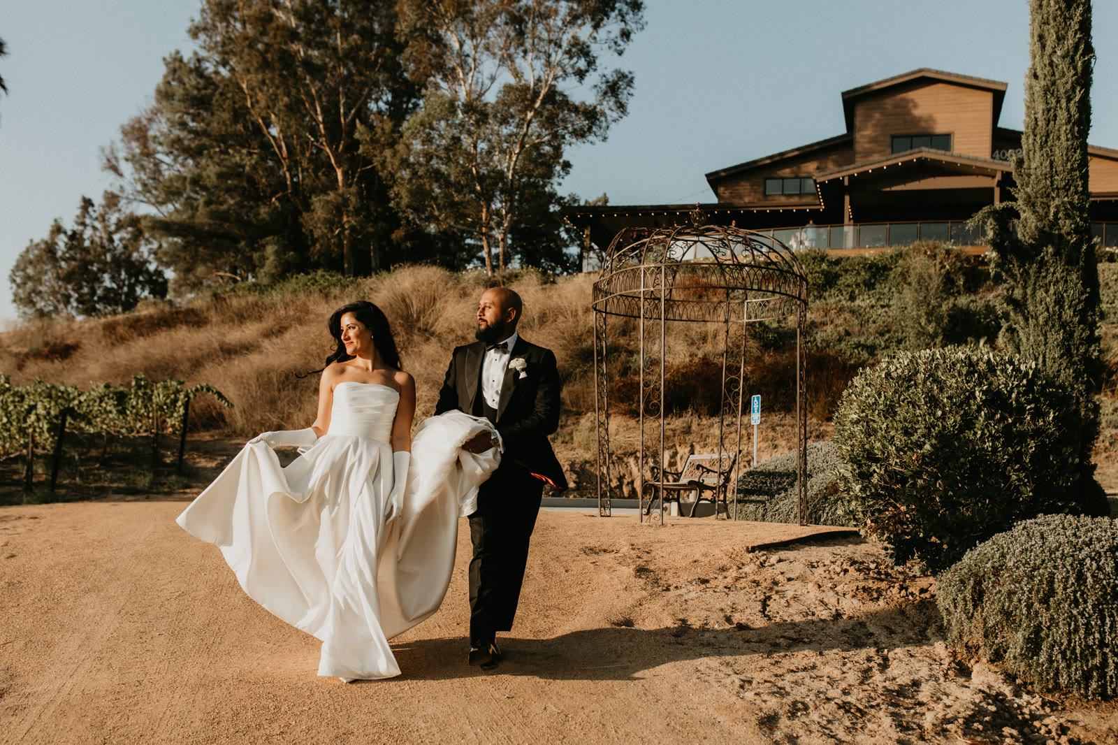 Bride and groom walking a vineyard path at a wedding venue